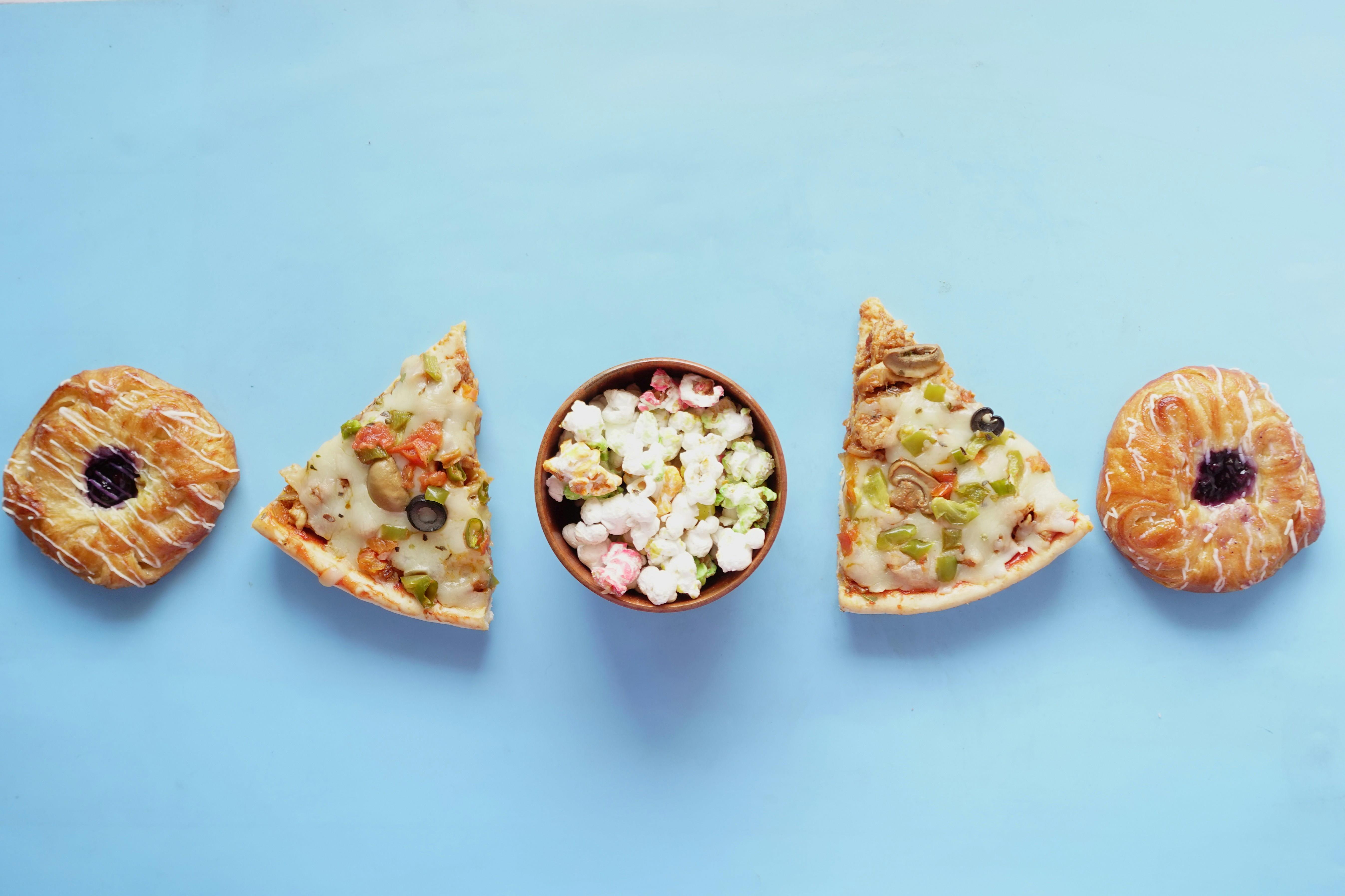 Výběr potravin, které obsahují spoustu prázdných kalorií – pizza, sladké pečivo, bonbóny.